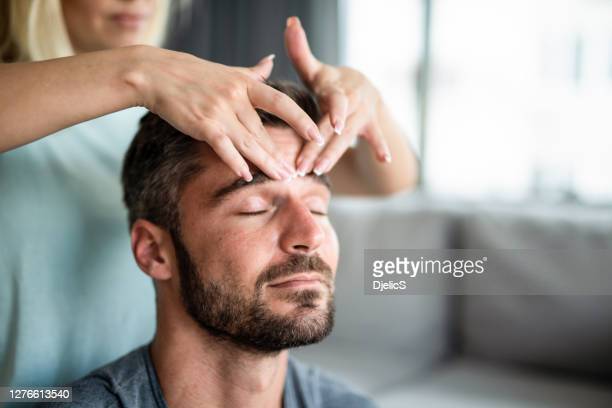 Unrecognizable-young-woman-giving-a-head-massage-to-her-husband-at-home